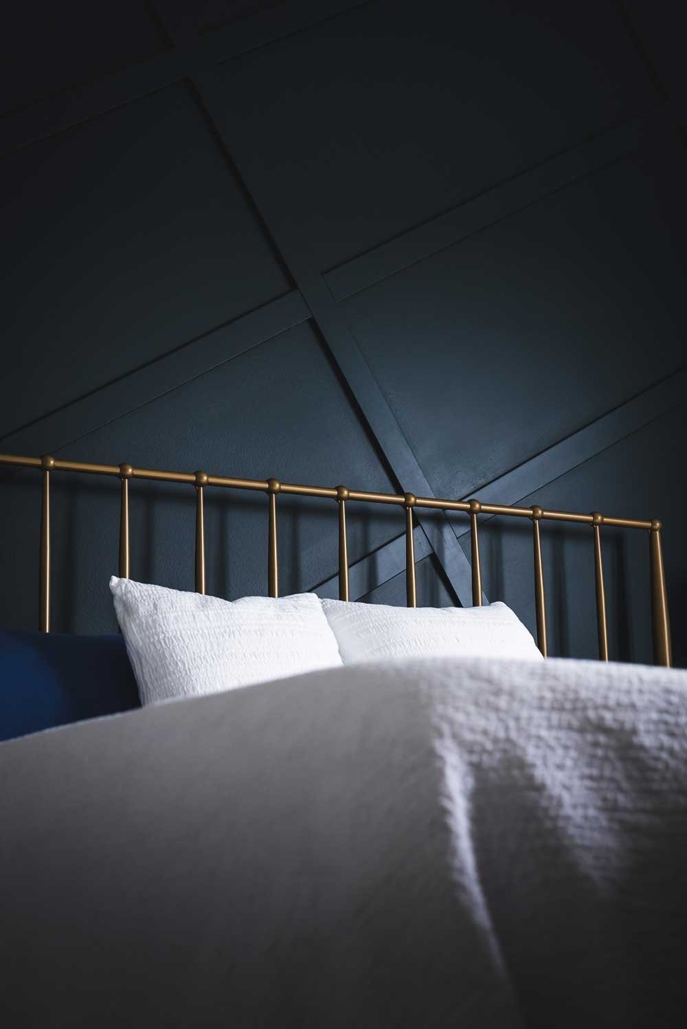 A decorative black wall above a bed in a bedroom at an AirBnb.