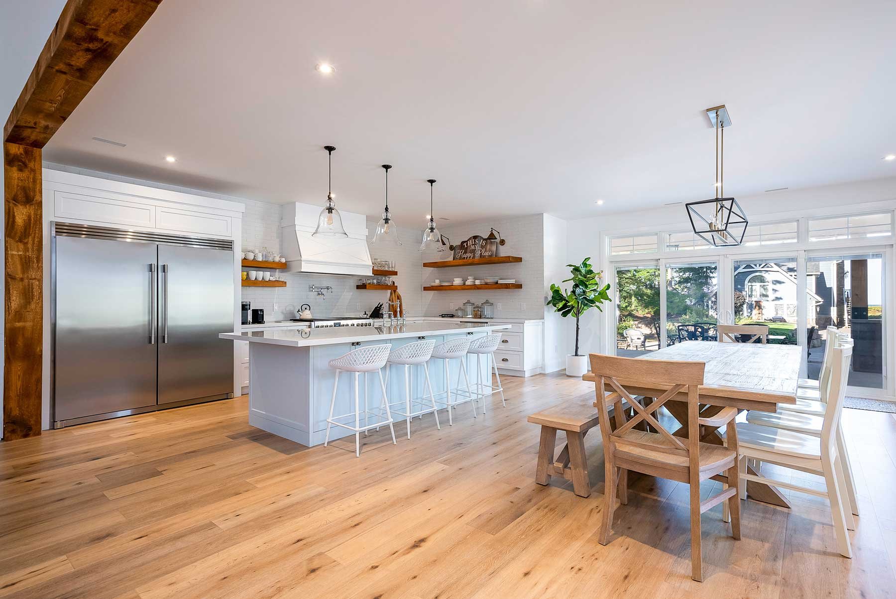 An open concept, kitchen and dining room with wite and wood tones in Wasaga Beach Ontario.