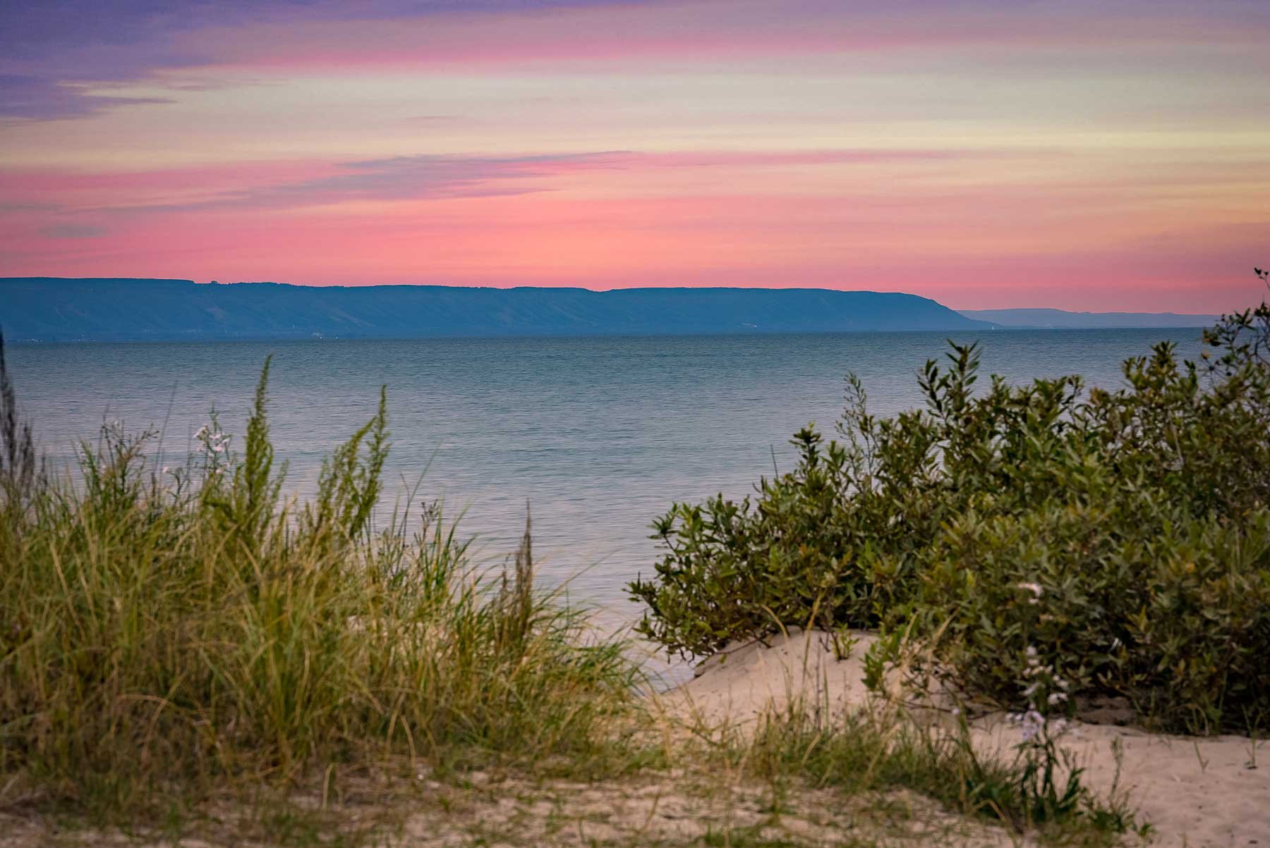 A twilight photo of Georgian Bay looking to The Blue Mountains from Wasaga Beach.