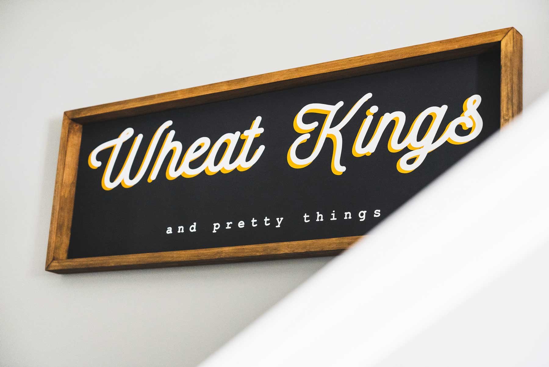 A sign for a house that says wheat kings and pretty things - a song title by The Tragically Hip band. This was taken during an Airbnb photo shoot.