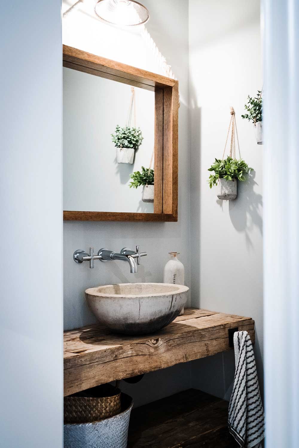 A creative bathroom with wood and stone accents.